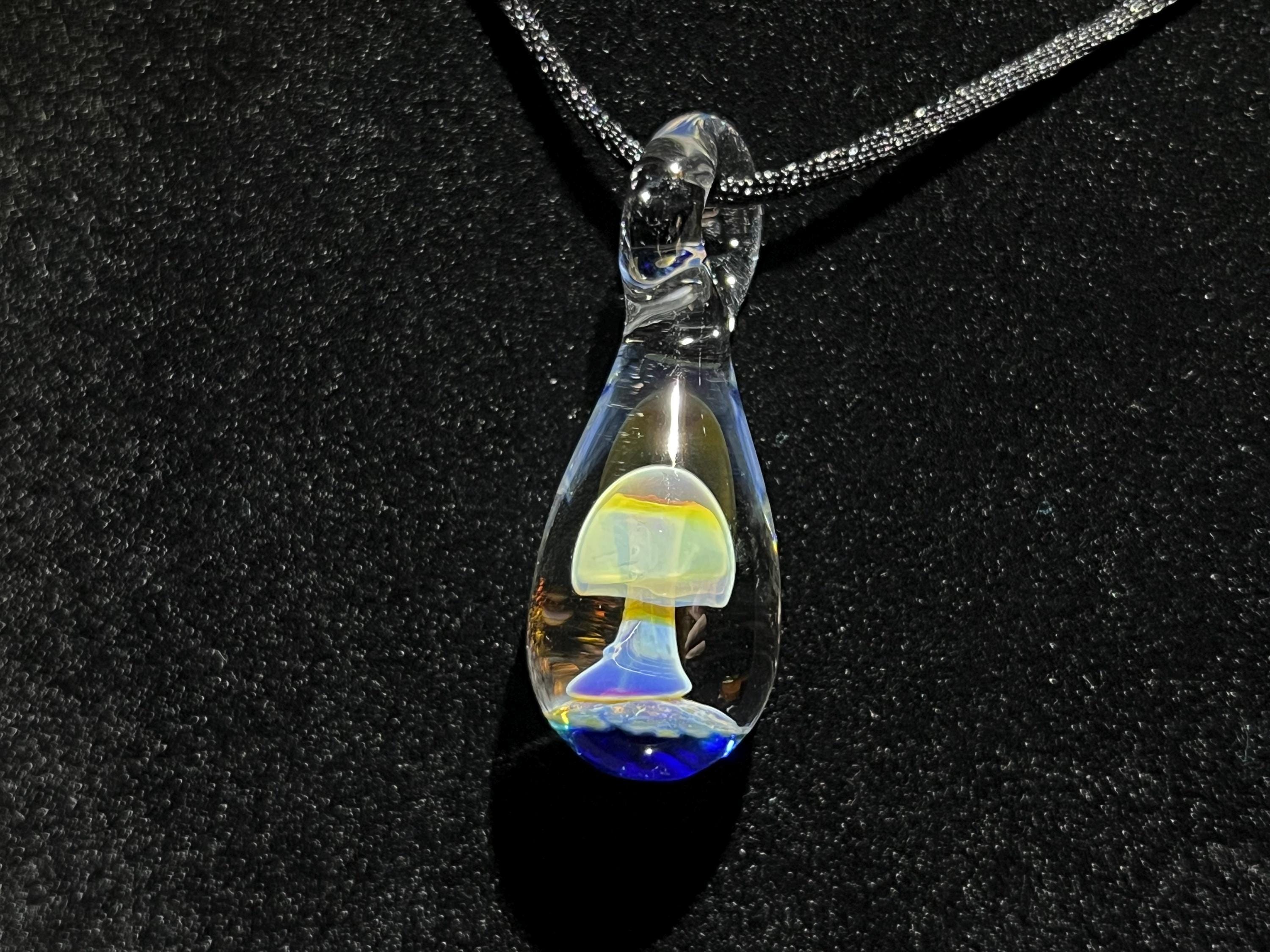 Glass smokey purple mushroom pendant with dark cobalt blue base. 18” necklace cord included