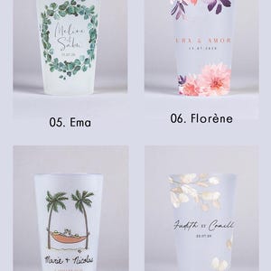 Op de afbeelding: Vier transparante glazen bekers met verschillende bloemenontwerpen en gepersonaliseerde tekst. De ontwerpen omvatten een groene krans, roze bloemen, palmbomen en witte takken. De tekst bevat namen en data.