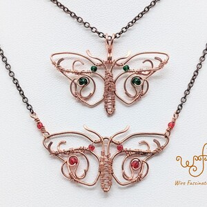 May include: Two copper wire butterfly necklaces with red and green gemstone accents. The top necklace features a green gemstone butterfly pendant, while the bottom necklace features a red gemstone butterfly pendant. The necklaces are on a white background with the text "Wire Fascinations" in the bottom right corner.
