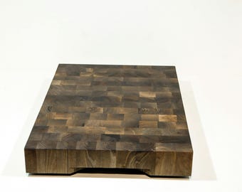 May include: A large, rectangular, brown butcher block cutting board made of wood.