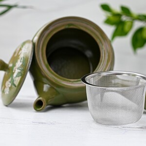 Puede incluir: Una tetera de cer&aacute;mica verde con un dise&ntilde;o floral y una tapa extra&iacute;ble. La tetera tiene un filtro integrado y un infusor de acero inoxidable a juego.