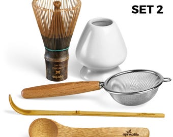 May include: A set of 5 matcha tea tools, including a bamboo whisk, a white ceramic bowl, a stainless steel strainer, a bamboo spoon, and a bamboo whisk holder. The set is labeled "SET 2".