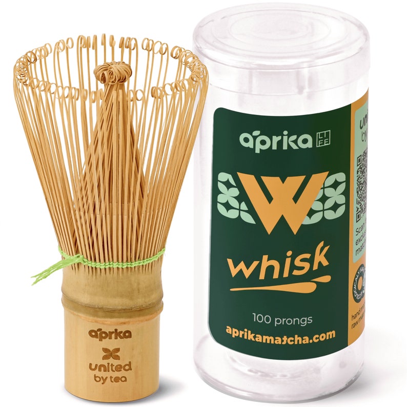 May include: A bamboo matcha whisk with 100 prongs in a clear plastic container. The container has a green label with the text "aprika whisk" and "aprikamatcha.com".