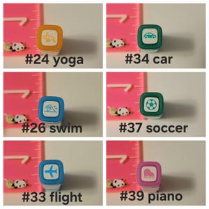 May include: A set of ten colorful rubber stamps with different icons and numbers. The icons include a yoga pose, a car, a swimmer, a soccer ball, an airplane, and a piano. The numbers range from 24 to 39.