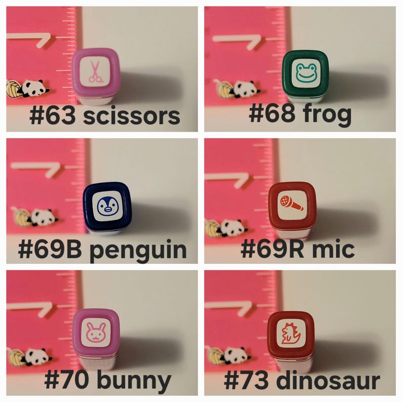 May include: Six colorful rubber stamps with different designs. The stamps are arranged in two rows of three. The top row includes a pair of scissors, a frog, and a microphone. The bottom row includes a penguin, a bunny, and a dinosaur.