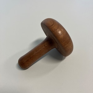 May include: A wooden mushroom-shaped tool with a rounded top and a long, slender handle.