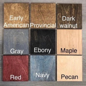 May include: Nine wood stain samples in a grid pattern. The stains are labeled: Early American, Provincial, Dark Walnut, Gray, Ebony, Maple, Red, Navy, and Pecan.