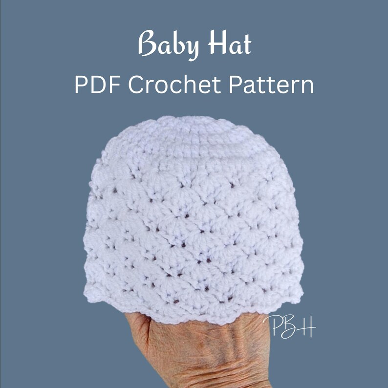 Peut inclure: Un bonnet de b&eacute;b&eacute; blanc crochet&eacute; avec un bord festonn&eacute; est tenu dans une main. Le chapeau est le point central, avec le texte "Baby Hat PDF Crochet Pattern" en &eacute;criture blanche au-dessus. Le fond est bleu-gris uni.