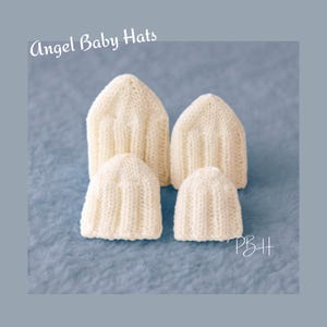 Könnte beinhalten: Vier cremefarbene, gestrickte Babyhüte sind auf einer strukturierten blauen Oberfläche angeordnet. Die Hüte sind unterschiedlich groß, mit zwei größeren und zwei kleineren. Der Text "Angel Baby Hats" steht in Kursivschrift oben im Bild.