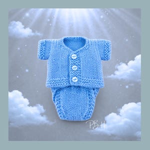 May include: A light blue knitted baby outfit, including a short-sleeved cardigan with three white buttons and matching diaper cover. The outfit is displayed against a cloudy, light blue background.