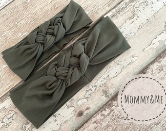 May include: Two olive green knotted headbands, made of soft fabric, with the text "Mommy & Me" in a white circle.