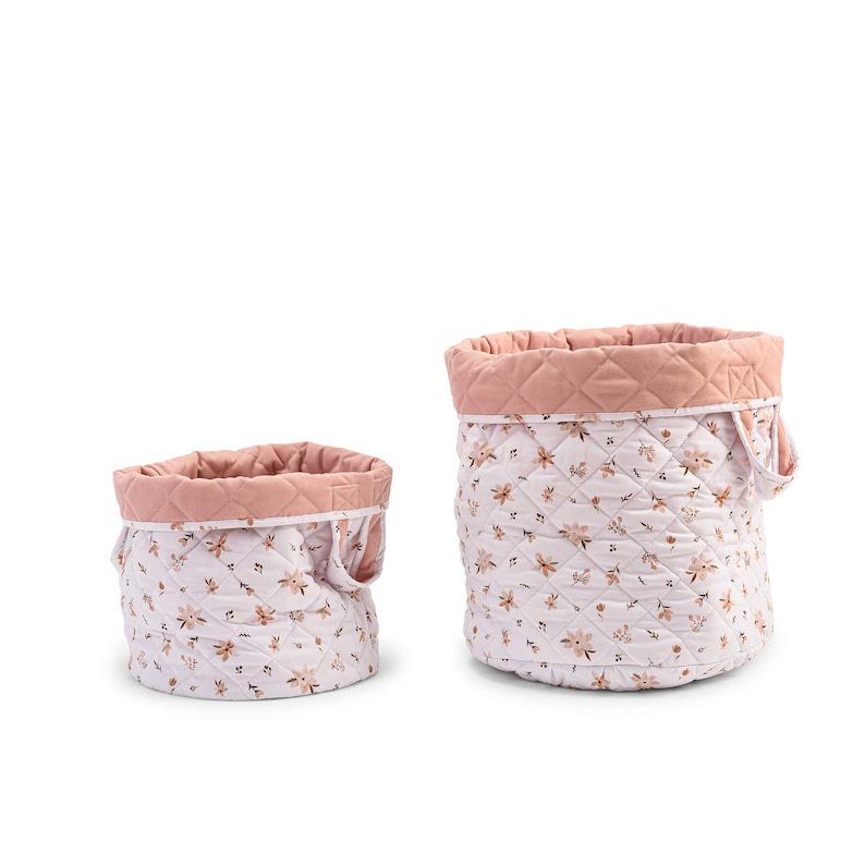 K&ouml;nnte beinhalten: Zwei gepolsterte Aufbewahrungsk&ouml;rbe mit Blumenmustern. Der gr&ouml;&szlig;ere Korb ist rosa mit wei&szlig;en Blumen und der kleinere Korb ist wei&szlig; mit rosa Blumen.