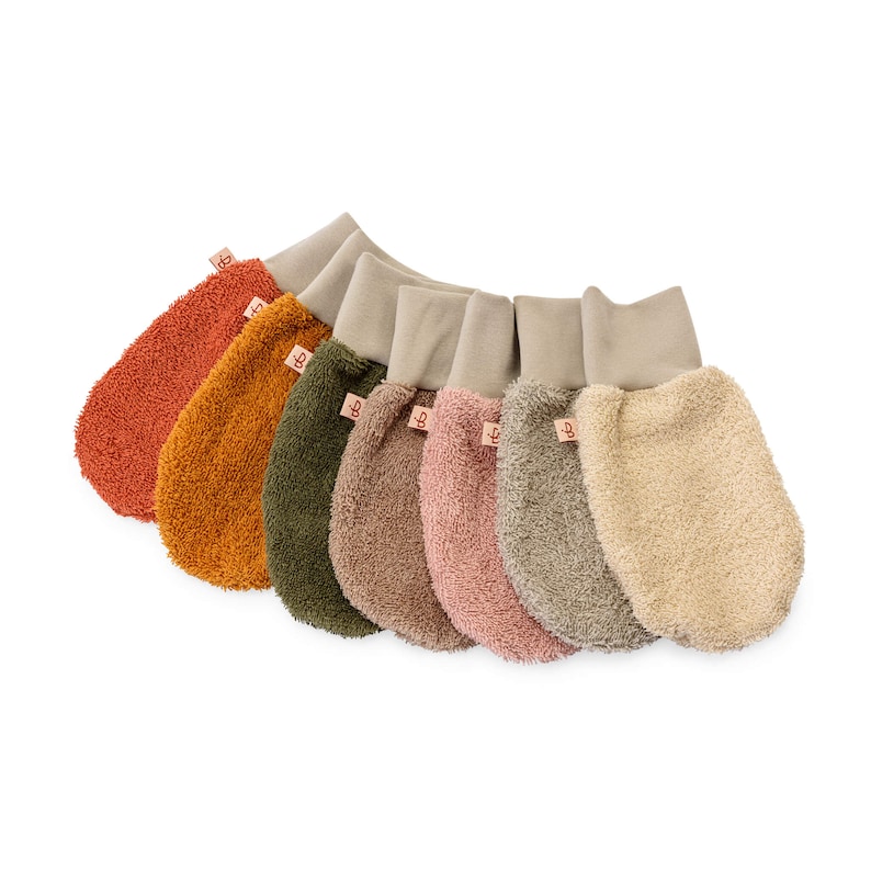 May include: Set of seven colorful baby washcloths with a soft, textured surface. Each washcloth has a brown leather tag with the letter "B" on it.