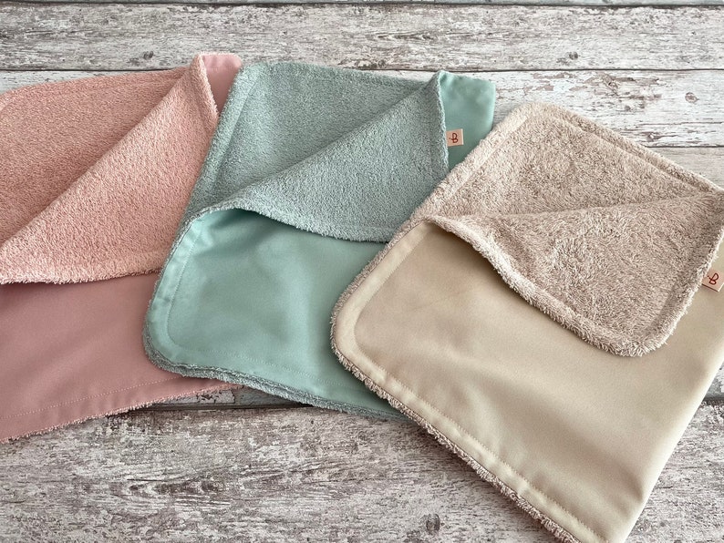 K&ouml;nnte beinhalten: Drei weiche, pl&uuml;schige Babydecken in Rosa, Hellblau und Beige. Jede Decke hat eine glatte und eine strukturierte Seite.