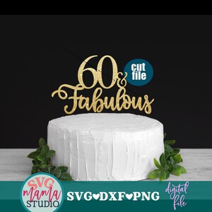 以下が含まれることがあります： 「60 & Fabulous」という文字と円の中に「cut file」という文字が書かれた、金色のグリッターケーキトッパー。トッパーは白いケーキの上にあり、背景には緑の葉があります。