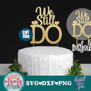 Könnte beinhalten: Goldener Glitzer-Kuchentopper mit dem Text "We Still Do" und zwei Herzen. Der Topper befindet sich auf einem weißen Kuchen mit grünen Blättern. Der Text "cut file" befindet sich in einem blauen Kreis und der Text "included" befindet sich in einem schwarzen Kreis.
