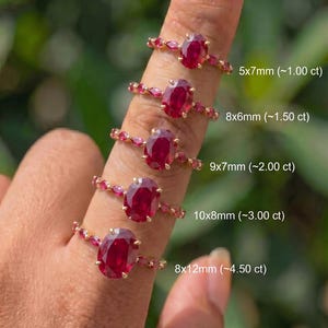 Puede incluir: Cinco anillos de oro con rubíes rojos de corte ovalado en varios tamaños: 5x7mm (~1.00 ct), 8x6mm (~1.50 ct), 9x7mm (~2.00 ct), 10x8mm (~3.00 ct) y 8x12mm (~4.50 ct). Cada banda de anillo tiene pequeñas piedras rojas de corte marquesa.