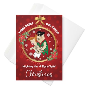 Puede incluir: Una tarjeta de Navidad con Pedro y Vilma Picapiedra dentro de un adorno dorado. La tarjeta tiene las frases "Yabba Dabba Doo Baby!!!" y "Wishing You A Rock-Solid Christmas" sobre un fondo rojo con copos de nieve y flores de Pascua. Incluye un sobre blanco.