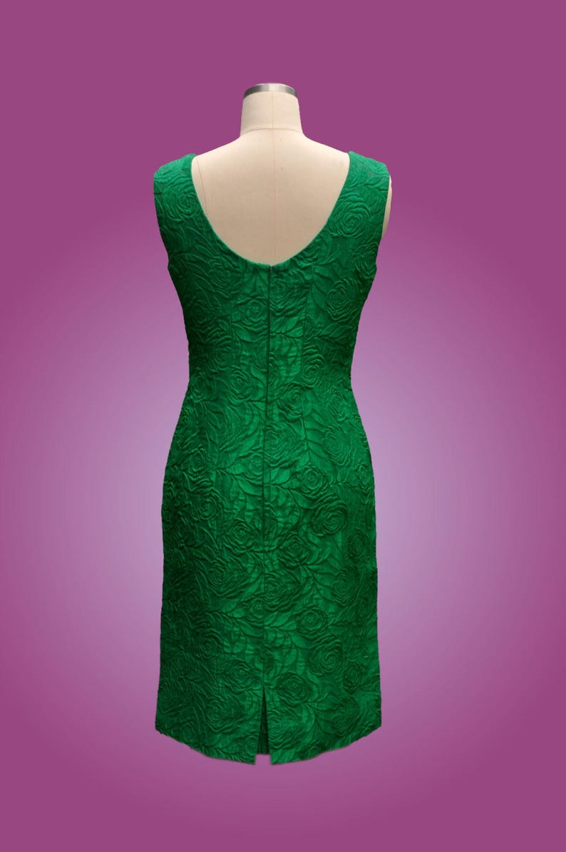 Puede incluir: Un vestido verde esmeralda sin mangas con estampado de rosas. El vestido tiene una silueta ajustada y una cremallera en la espalda.