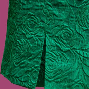 Puede incluir: Una falda verde con estampado de rosas y una abertura en la espalda.