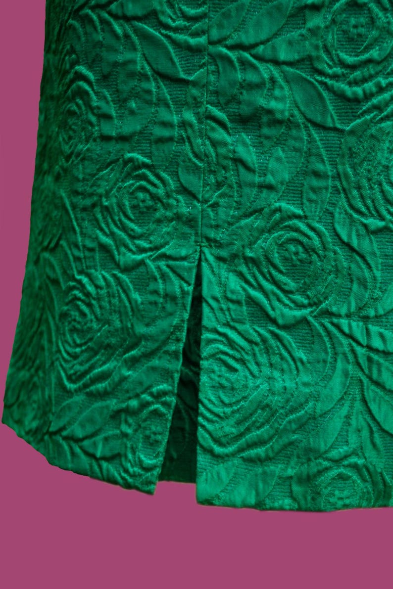 Puede incluir: Una falda verde con estampado de rosas y una abertura en la espalda.