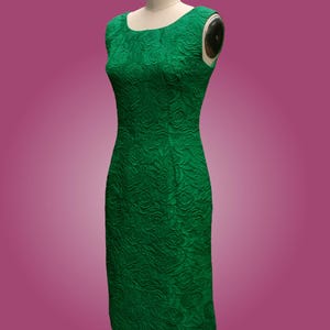 Puede incluir: Un vestido verde sin mangas con estampado floral. El vestido es entallado y tiene un escote recto.