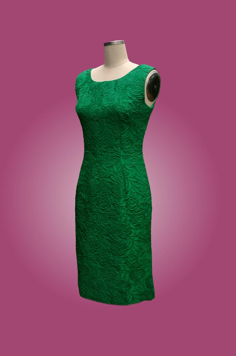 Puede incluir: Un vestido verde sin mangas con estampado floral. El vestido es entallado y tiene un escote recto.