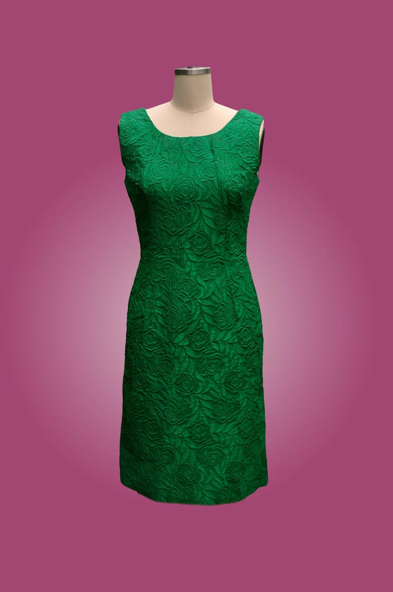 Puede incluir: Un vestido verde sin mangas con estampado floral. El vestido es entallado y tiene un escote recto.