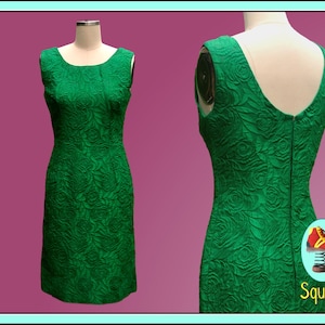 Puede incluir: Un vestido verde esmeralda sin mangas con estampado floral. El vestido es entallado y tiene un escote recto.