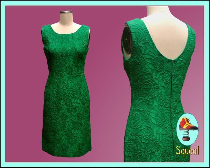 Puede incluir: Un vestido verde esmeralda sin mangas con estampado floral. El vestido es entallado y tiene un escote recto.