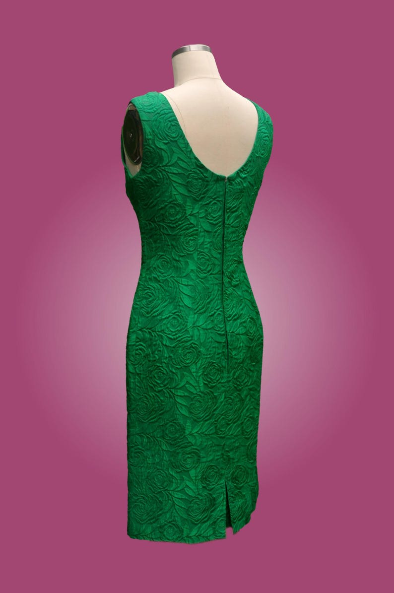 Puede incluir: Un vestido verde esmeralda sin mangas con un patr&oacute;n floral en relieve. El vestido tiene un escote en V y una cremallera en la espalda.