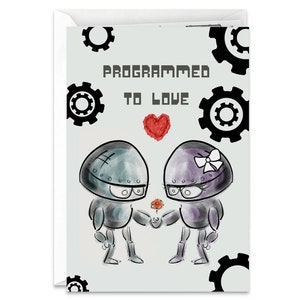 May include: A greeting card with a light gray background featuring two robots in love. The robots are holding a red flower and a heart. The text on the card reads "Programmed to Love".