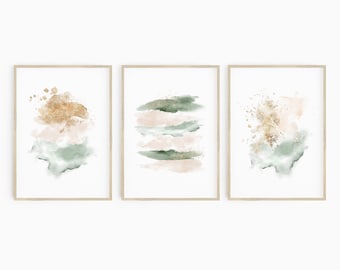 Könnte beinhalten: Set aus drei abstrakten Aquarelldrucken im minimalistischen Stil. Die Drucke zeigen Grüntöne, Rosa und Gold, wobei zwei der Drucke einen goldenen Spritzeffekt aufweisen.