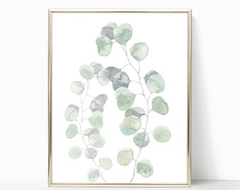 May include: A framed watercolor print of a leafy branch with green and blue leaves. The leaves are arranged in a circular pattern, creating a delicate and elegant design.