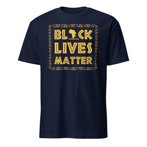 Peut inclure: Un t-shirt bleu marine avec un imprim&eacute; graphique d'un contour stylis&eacute; du continent africain en jaune et le texte "Black Lives Matter" en jaune avec une bordure &agrave; motifs rouge, vert et jaune.