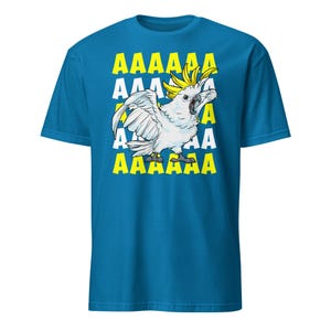 Vibrant red T-shirt featuring a cartoon sulfur-crested cockatoo screaming with its wings spread against a background of repeating "AAAAAA" text, ideal for bird owners, parrot lovers, and fans of chaotic, loud-humor graphic apparel.