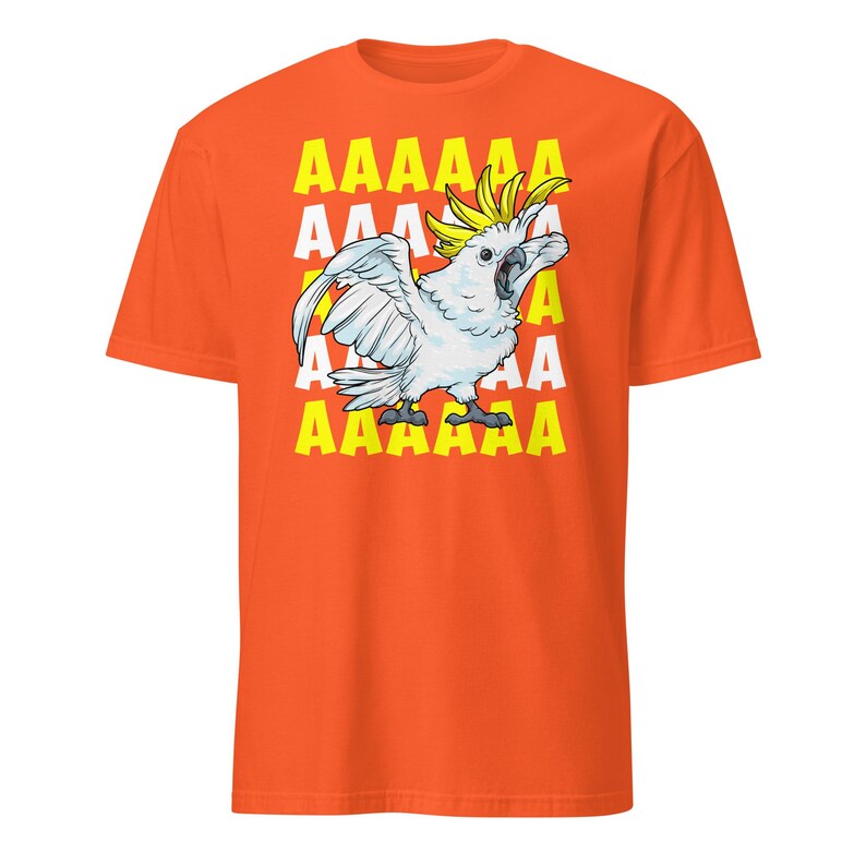 Vibrant red T-shirt featuring a cartoon sulfur-crested cockatoo screaming with its wings spread against a background of repeating "AAAAAA" text, ideal for bird owners, parrot lovers, and fans of chaotic, loud-humor graphic apparel.