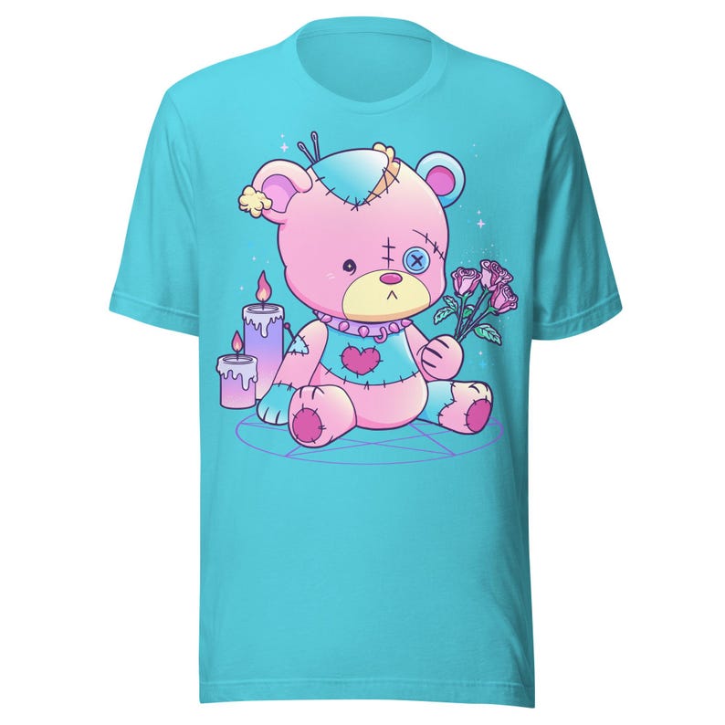 May include: A turquoise t-shirt with a pink and blue stitched teddy bear holding a bouquet of pink roses. The bear is sitting on a pentagram with two purple candles.
