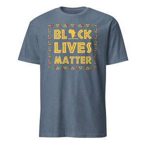 Peut inclure: Un t-shirt bleu avec un motif jaune qui dit "Black Lives Matter" avec un contour du continent africain au milieu du mot "Black". Le motif est entour&eacute; d'une bordure color&eacute;e.