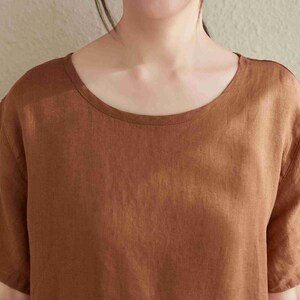 Puede incluir: Una camisa de lino marr&oacute;n de manga corta con cuello redondo.