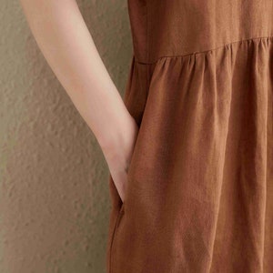 Puede incluir: Un vestido de lino marr&oacute;n con falda fruncida y un dise&ntilde;o sencillo y sin mangas.