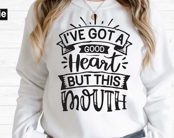 Puede incluir: Una sudadera blanca con un gráfico negro que dice "Tengo un buen corazón pero esta boca".