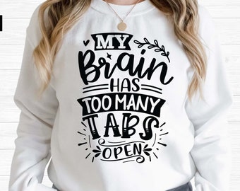 Op de afbeelding: Een wit sweatshirt met zwarte tekst die "My brain has too many tabs open" zegt.