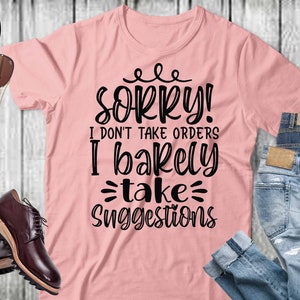 May include: A pink t-shirt with the text "Sorry! I don't take orders I barely take suggestions" in black lettering.