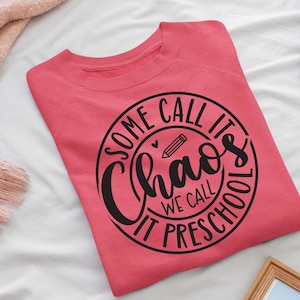 May include: A pink sweatshirt with a black circle design that says "Some call it chaos we call it preschool" with a pencil and heart inside the circle.