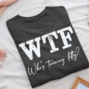May include: A dark gray sweatshirt with the text "WTF Who's turning fifty?" printed in white.