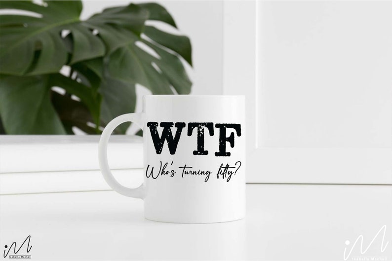 May include: White ceramic coffee mug with black text that reads "WTF Who's turning fifty?"