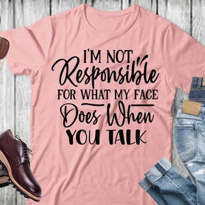 Könnte beinhalten: Ein pinkfarbenes T-Shirt mit dem Text "I'm not Responsible for what my face does when you talk" in schwarzer Schrift.