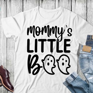 May include: White t-shirt with black text that reads "Mommy's Little Boo" with two ghost illustrations.