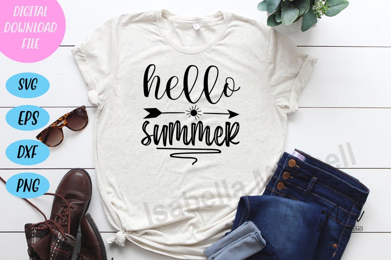 Peut inclure: Un t-shirt blanc avec le texte "hello summer" en lettres cursives noires. Une fl&egrave;che noire avec un graphique de soleil pointe vers la droite. Le t-shirt est pos&eacute; sur une surface en bois blanc avec une paire de lunettes de soleil, des bottes brunes et un jean bleu.